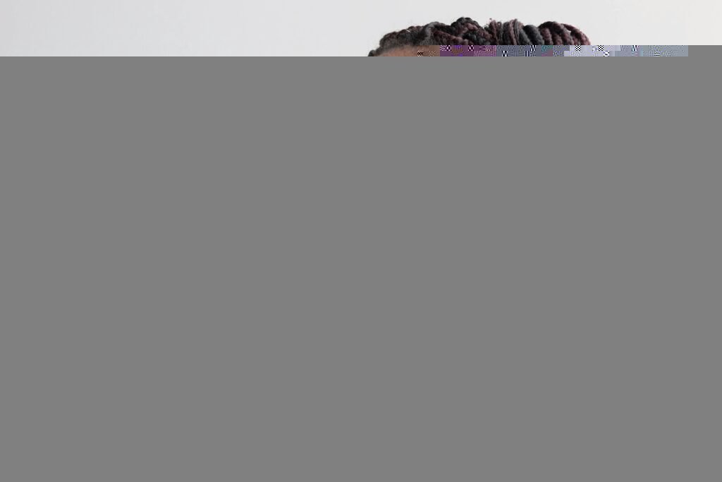 Elegant portrait featuring a woman in glasses with braided hairstyle and floral top.