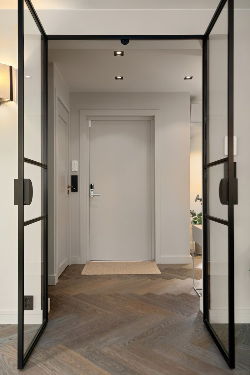 A long hallway with a glass door leading to another room